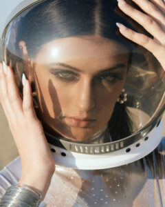 Photo of model in spacesuit with desert backgorund.