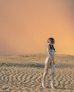 Photo of model in spacesuit with desert backgorund.