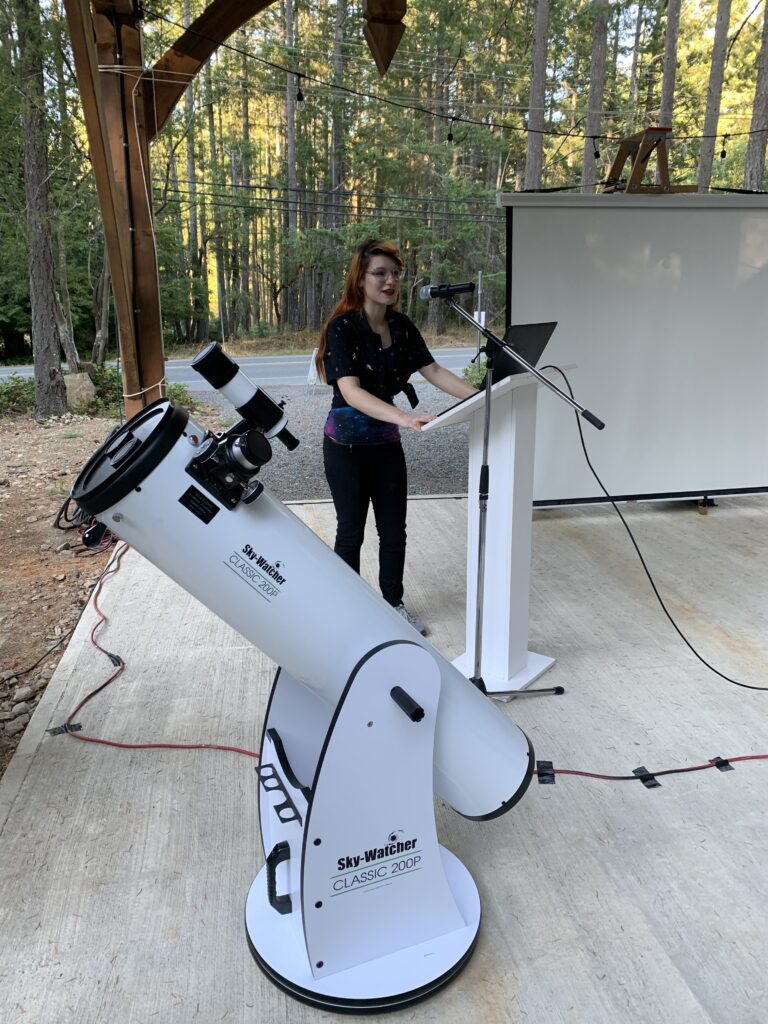 Photo of SEDS staff member leading outreach event behind telescope